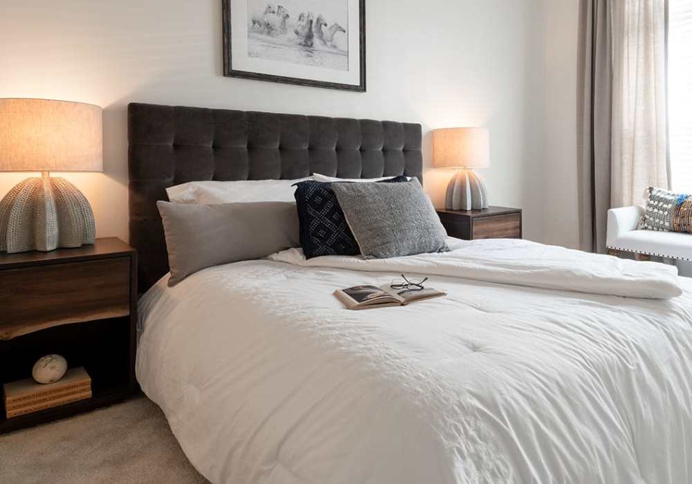Model bedroom with carpeted flooring at The Heron Downtown in Baton Rouge, Louisiana