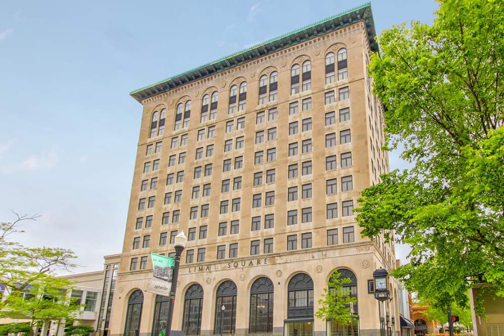 View of building with lush greenery surrounding the entrance at 43 Town Square in Lima, Ohio