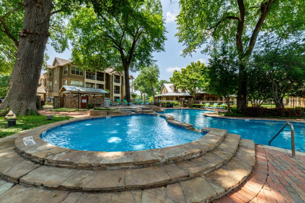Stone steps to hot tub next to pool at Marquis at Bellaire Ranch in Fort Worth, Texas
