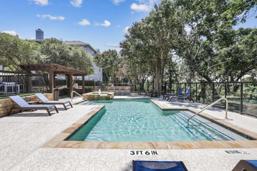 View of pool area with sun decks at Vail Cliffside in Arlington. TX