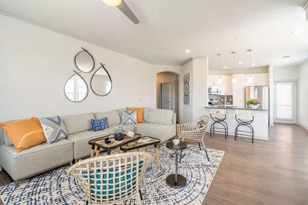 Spacious living room with wood-style flooring at Caliber at Flatirons in Broomfield, Colorado