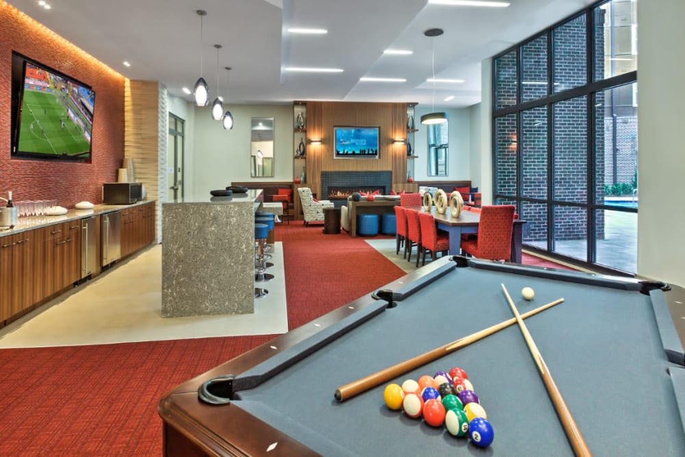 Pool table with community kitchen and dining area in background at Marq Midtown 205 in Charlotte, North Carolina