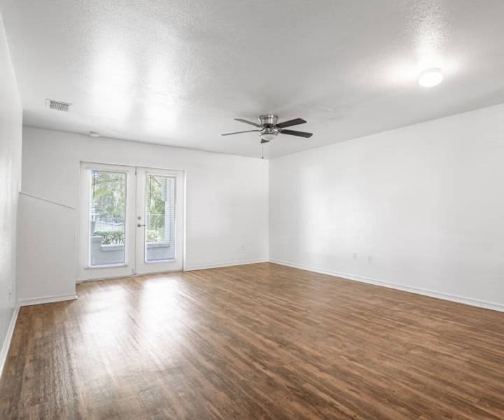 Living room with a sliding door leading to the private patio at Cypress Commons in Wildwood, Florida
