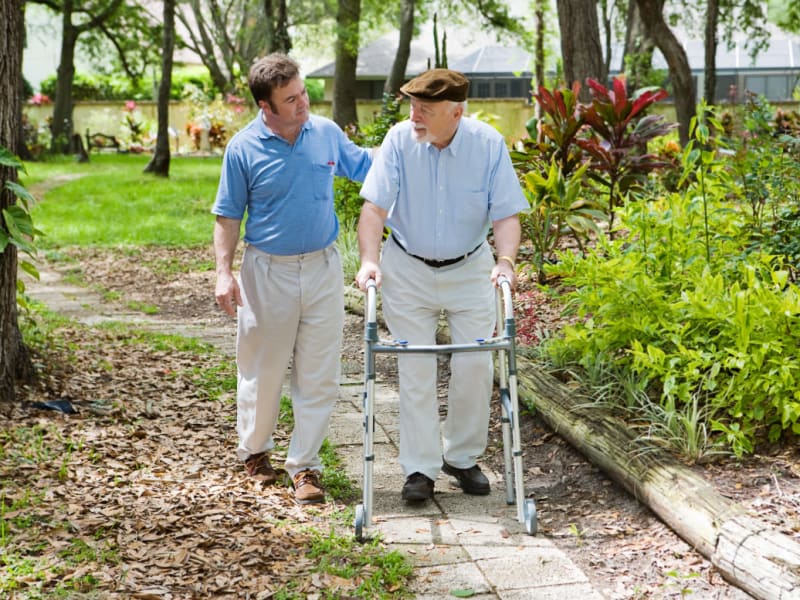 Resident with a walker being assisted by a caretaker at East Troy Manor in East Troy, Wisconsin