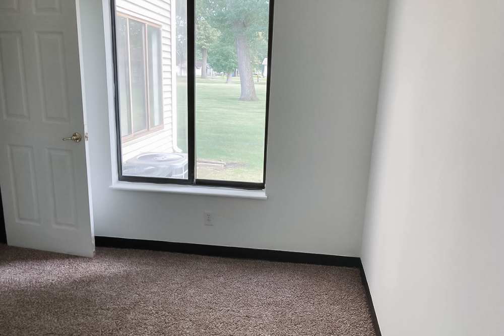 Bedroom with plush carpeting and large window at Oakview in Delta, Ohio
