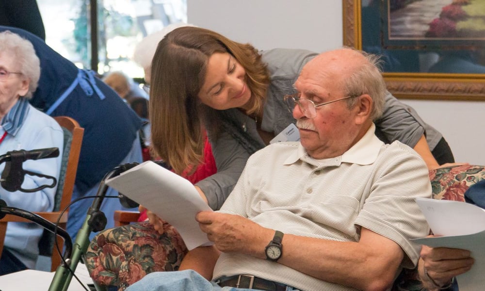 Resident getting help reading sheet music at White Oaks in Lawton, Michigan