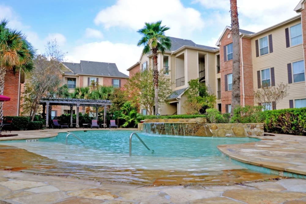 The community pool and surrounding apartments at Compass at Windmill Lakes in Houston, Texas