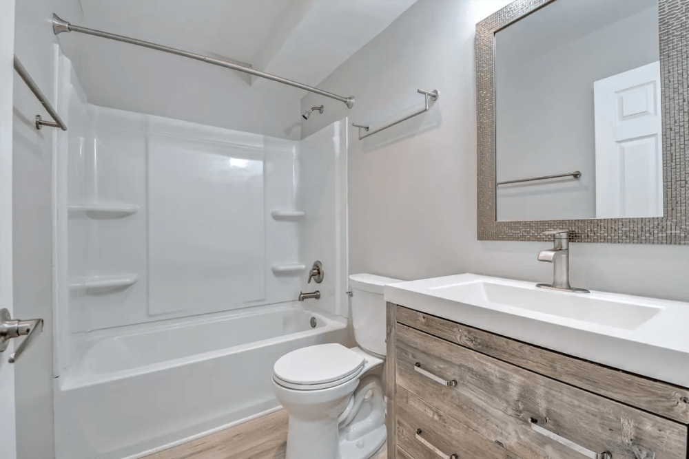 Washroom with attached bathtub and mirror at Terraces of Elk Grove in Elk Grove Village, Illinois