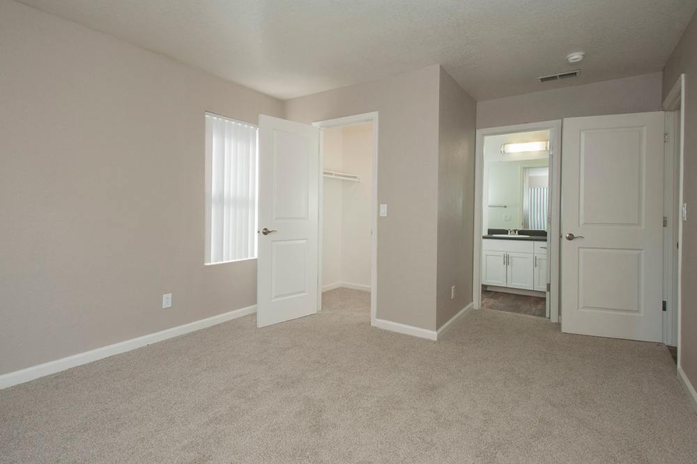 Well-lit bedroom with bathroom at Sandpiper Village Apartment Homes in Vacaville,California