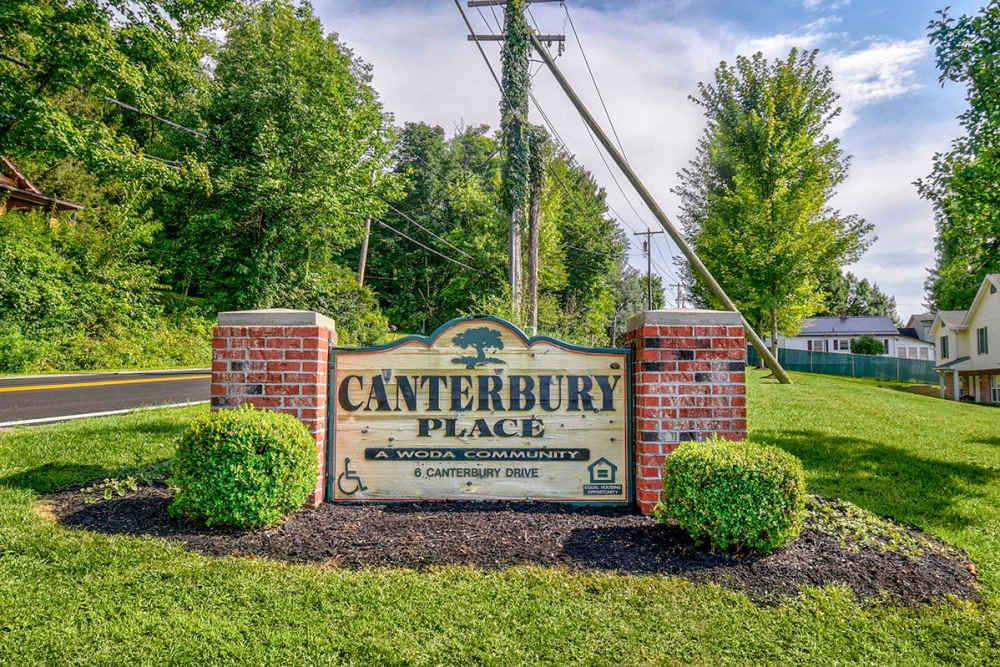 Community sign with landscaped greenery and trees in a residential area at Canterbury Place in Elkins, West Virginia