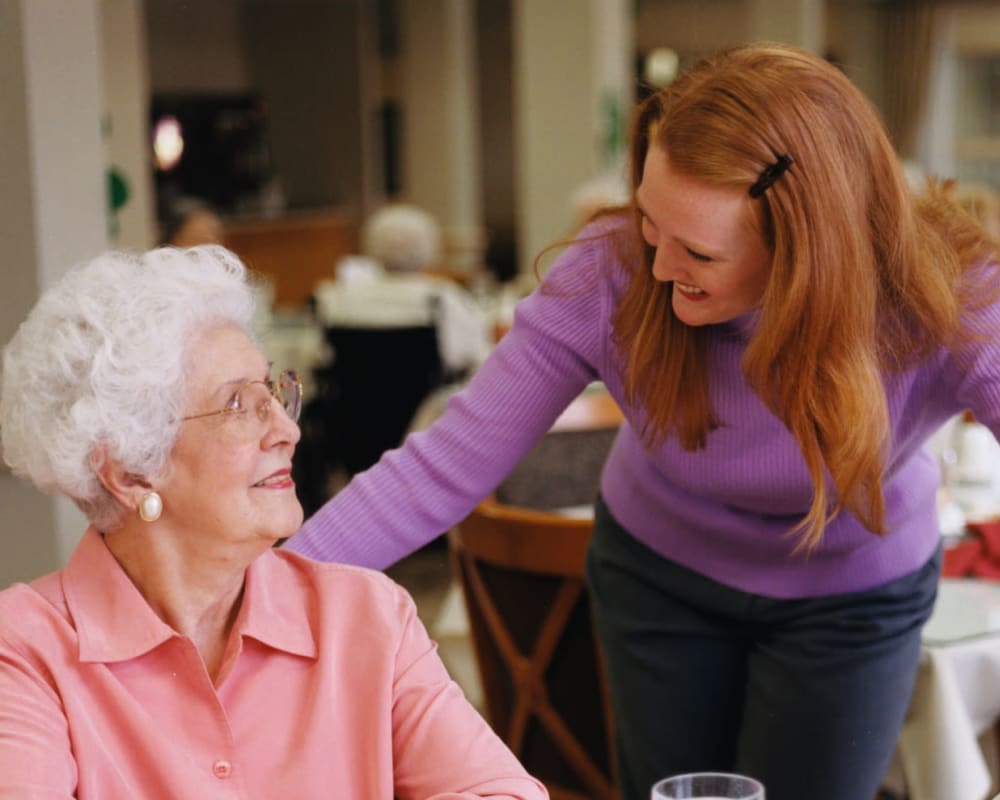 Staff chats with resident in dining room at Ramsey Woods in Cudahy, Wisconsin.