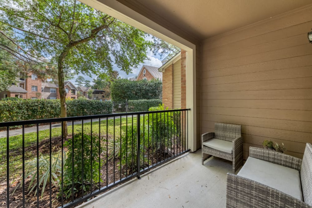 Private patio with sitting chairs overlooking walkway at Marquis at Kingwood in Kingwood, Texas