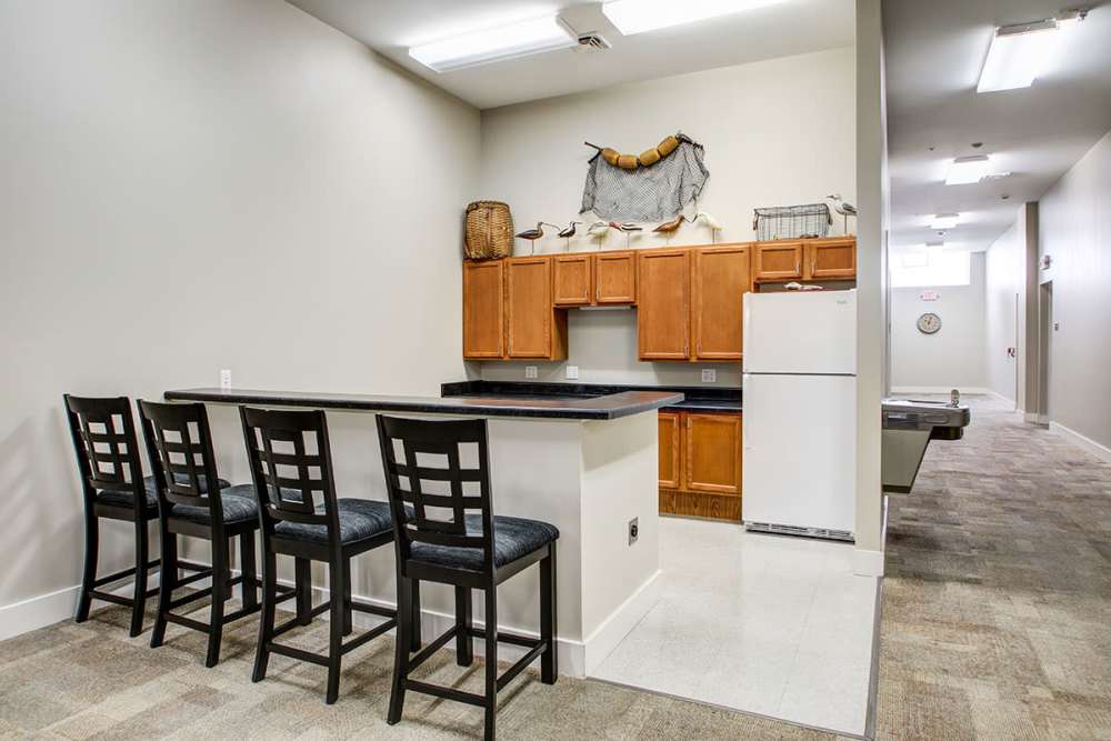Modern kitchen with granite countertops, stainless steel appliances, and bar seating for four at Lloyd House II in Menominee, Michigan