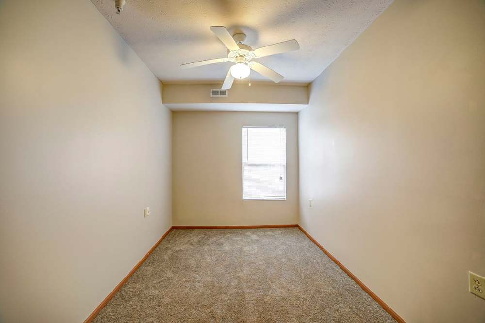 Bedroom of apartment with carpet flooring and ceiling fan at Brentwood Greene in Kokomo, Indiana