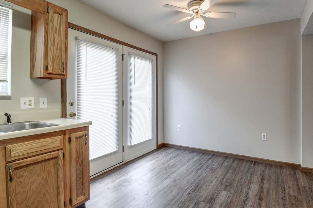 Bright kitchen with wood-style flooring and access to outdoor patio through double doors at Cedar Glen I in Morgantown, West Virginia