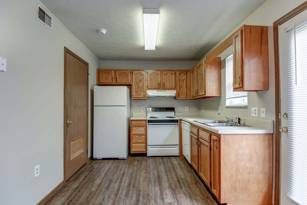 Bright kitchen with wood-style flooring, stainless steel appliances, and ample cabinet space at Cedar Glen I in Morgantown, West Virginia