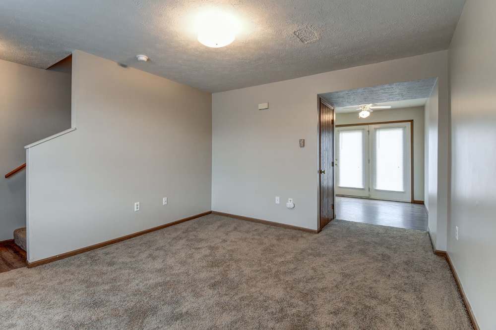 Spacious living area with carpet flooring and natural light from sliding glass doors at Cedar Glen I in Morgantown, West Virginia