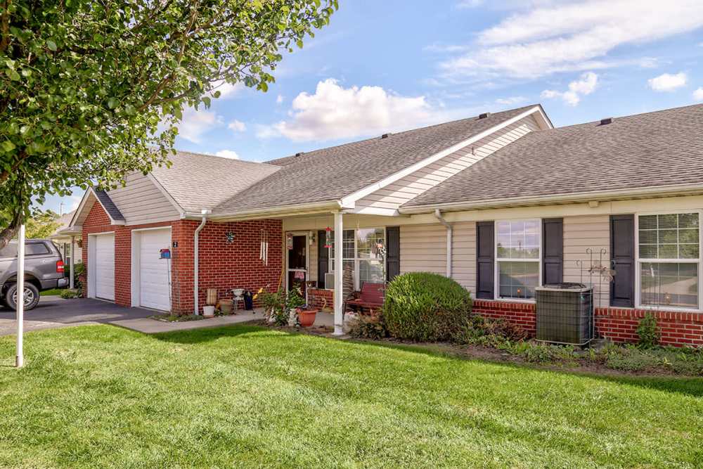 Charming apartment community with green lawn, brick exterior, and welcoming entrance surrounded by trees and shrubs at Heritage Greene in Washington Court House, Ohio