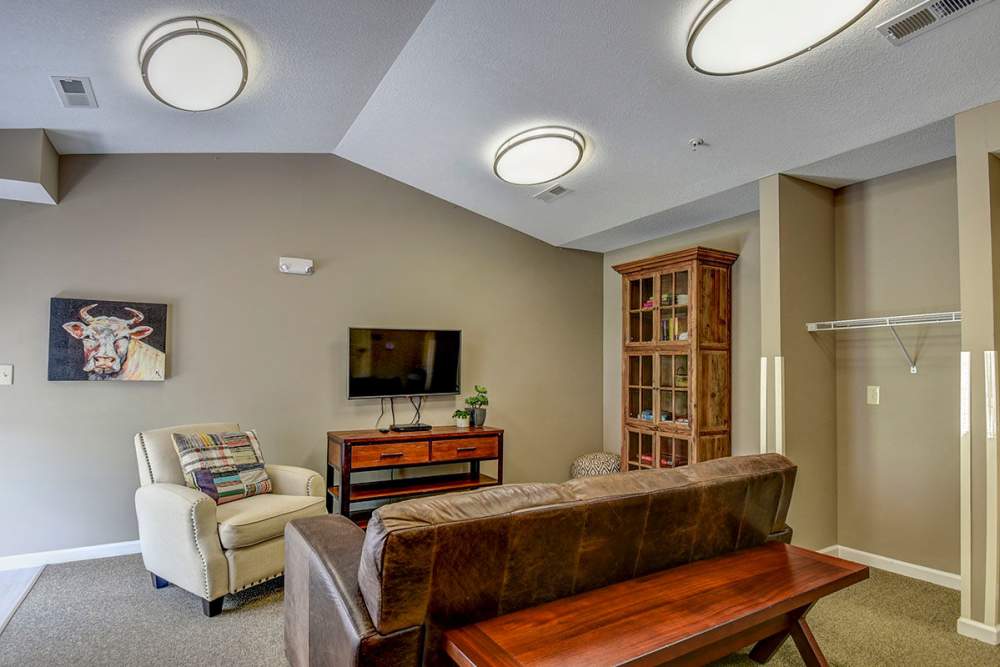 Cozy living room with modern furniture, flat-screen TV, and decorative artwork on the wall at Oak Valley Gardens in Glenville, West Virginia