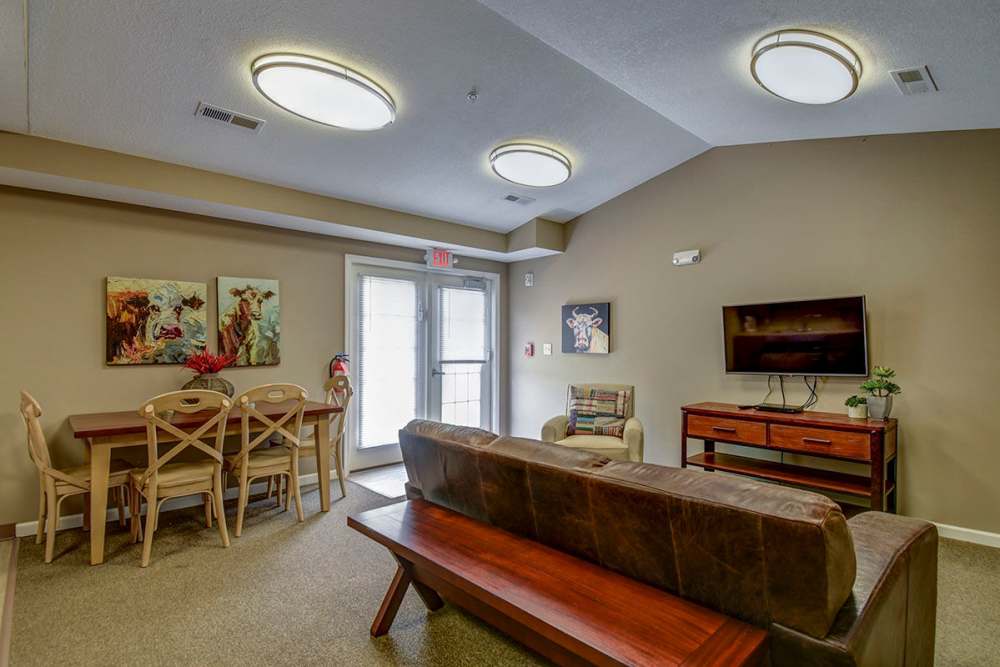 Cozy living area with wood-style flooring, dining table, and natural light from patio doors at Oak Valley Gardens in Glenville, West Virginia