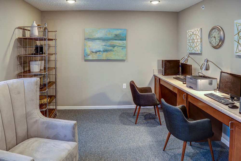 Modern business center with two computers, stylish chairs, and decorative shelving at Pebblecreek Crossing in Richmond, Kentucky