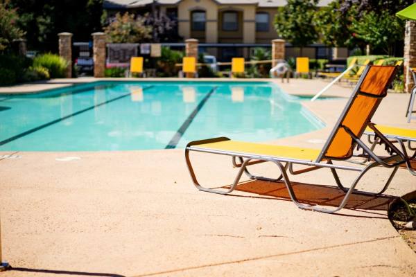 Lounge chair by the pool at Oak Brook Apartments in Rancho Cordova, California