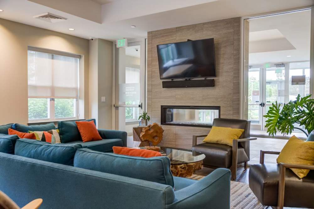 Community clubhouse with large couch, chair, fireplace and flat screen television at Gateway North in Lynn, Massachusetts