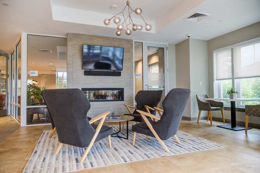 Community seating with chairs, fireplace and flat screen television at Gateway North in Lynn, Massachusetts
