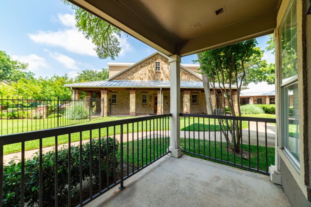 Private balcony surrounded by green grass and trees at Marquis at Bellaire Ranch in Fort Worth, Texas