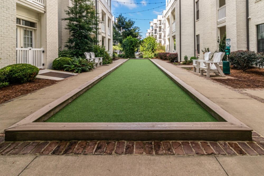 Long grassy dog run area with chairs and waste station on side at Marquis at Buckhead in Atlanta, Georgia