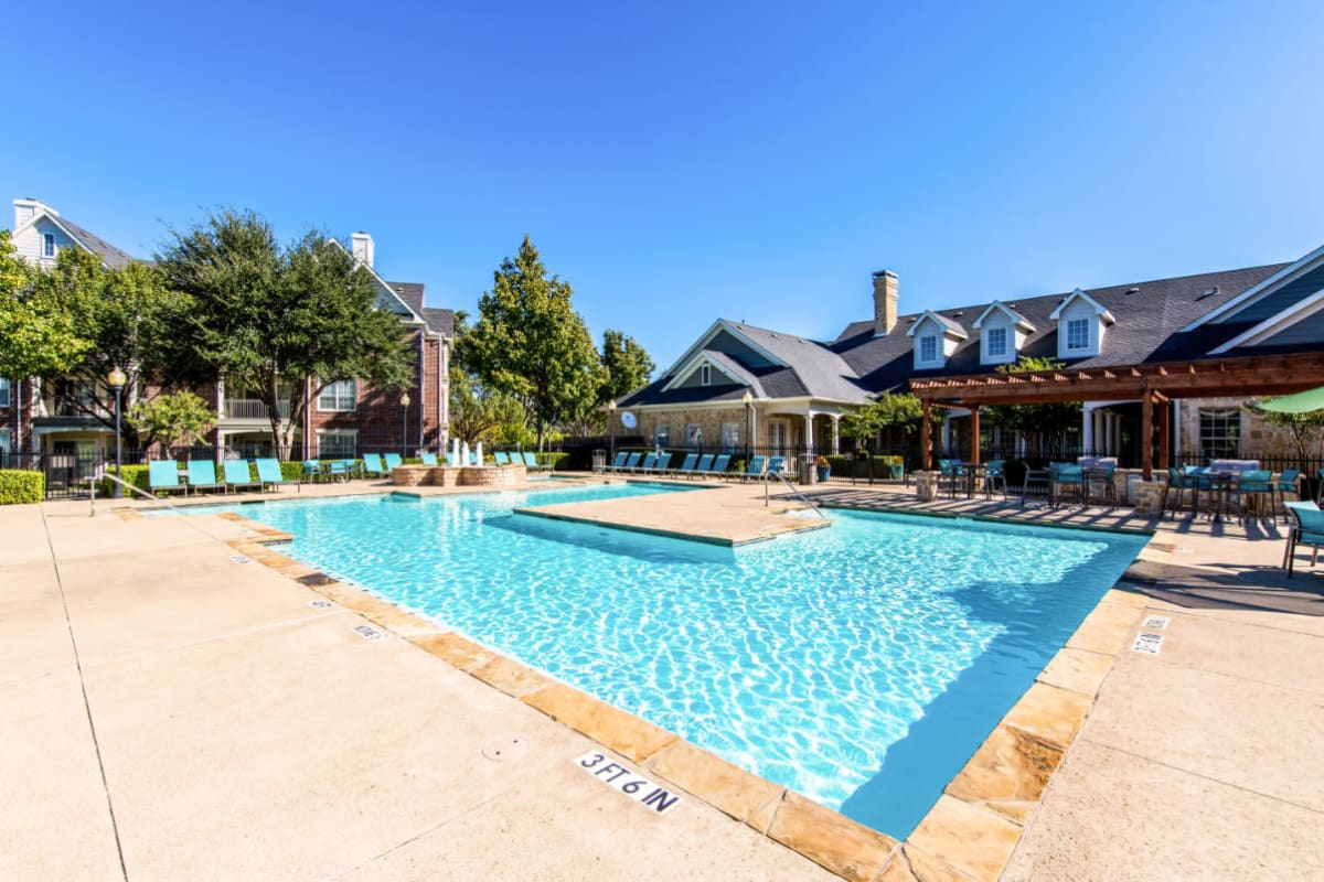 Sparkling pool surrounded by lounge chairs and gazebo area at Marquis at Silver Oaks in Grapevine, Texas