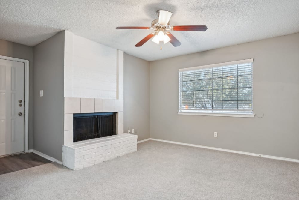 Living room with in home fireplace at Courts of Bedford in Bedford, Texas
