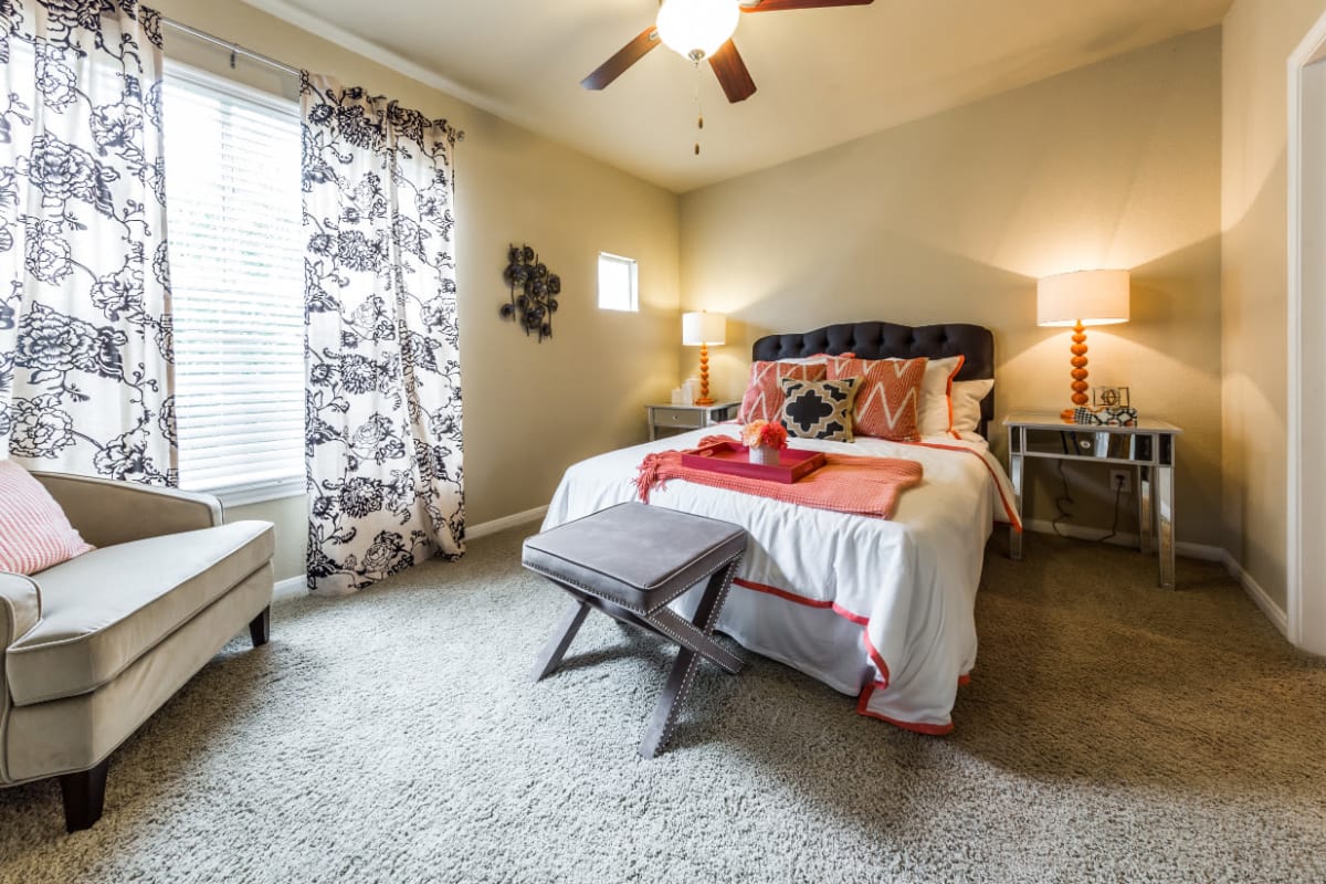 Cozy bedroom with carpet and large window at Marquis at Stonegate in Fort Worth, Texas