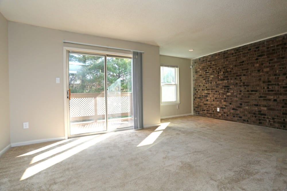 Large living room opening onto private balcony at Laurel Pines Apartments in Richmond, Virginia