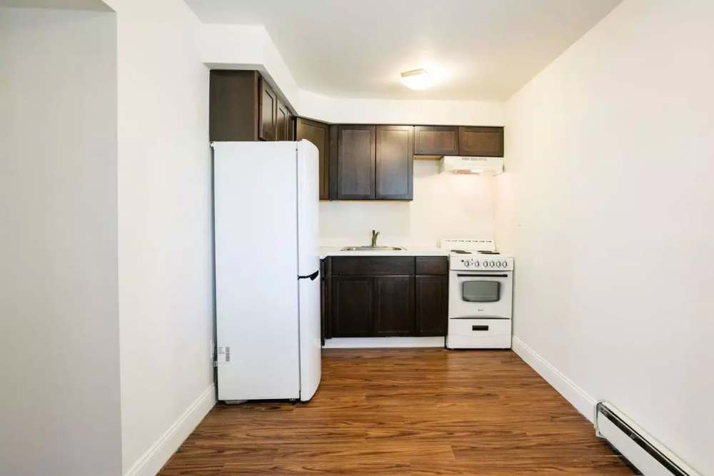 Fully-equipped kitchen with hard-wood style flooring at Detroit Living in Detroit, Michigan