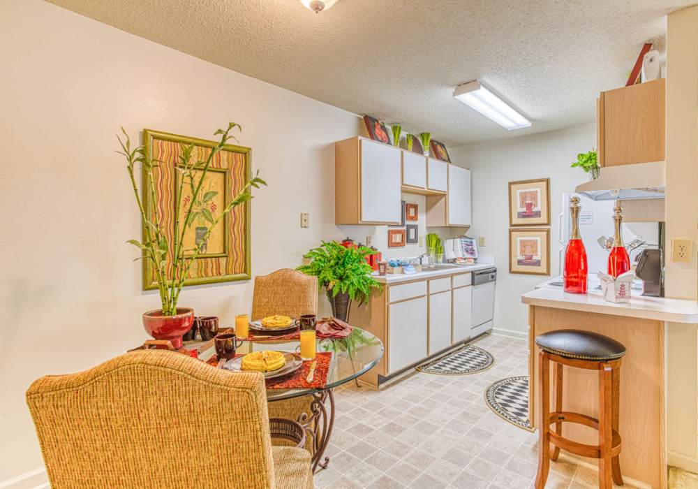 Table in dining room with an open layout that connects to fully-equipped kitchen with dishwasher at Brannigan Village in Winston Salem, North Carolina