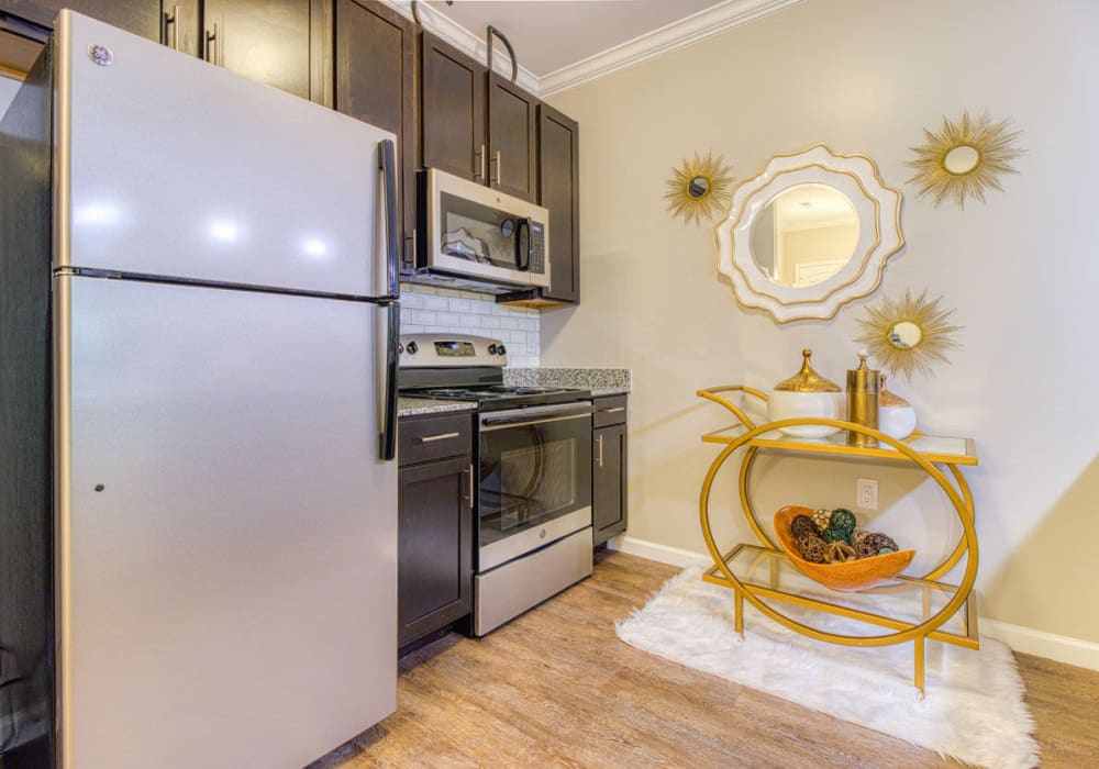 Fully equipped kitchen with stainless-steel fridge, drawer microwave, stove, and oven at Greymont Village in Asheville, North Carolina