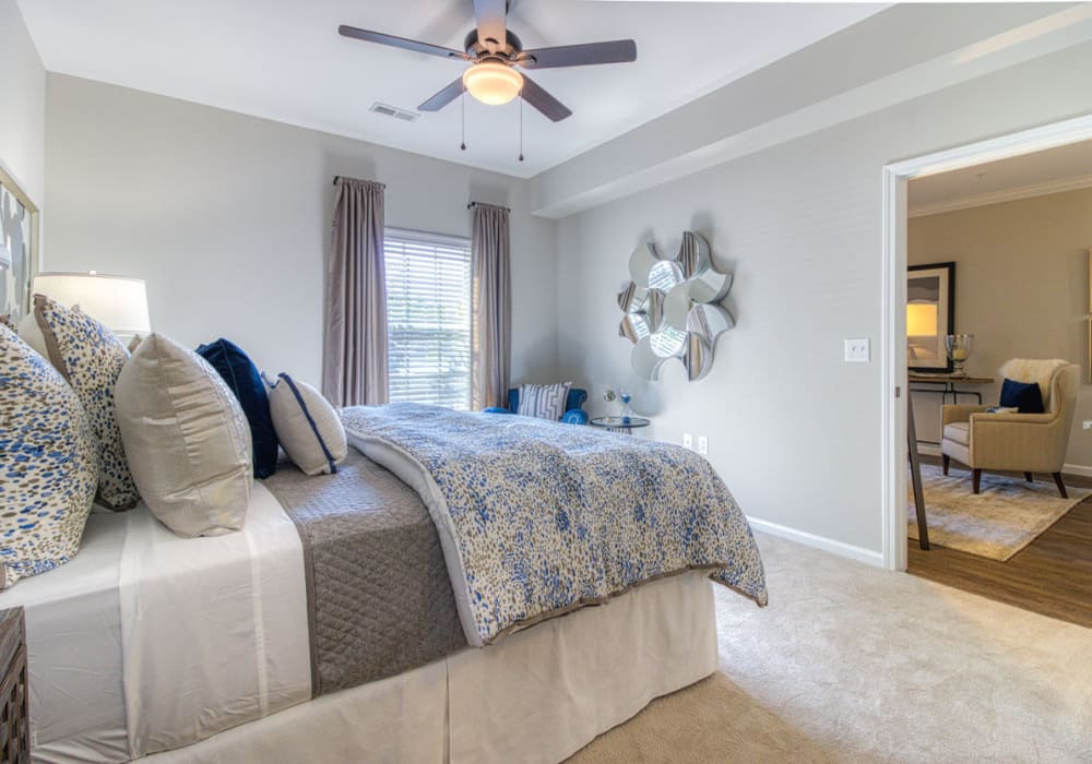 Minimal and clean style bedroom with ceiling fan, full bed, window, and close access to living room at Greymont Village in Asheville, North Carolina