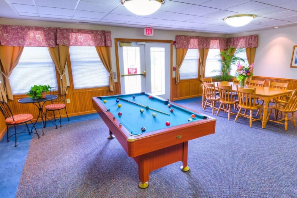 Game room with pool table and table for seating at Addington Place of Mount Pleasant in Mt Pleasant, Iowa