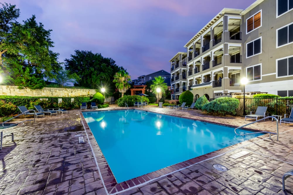 Lighted pool at sunset overlooking units at Marquis at Stone Oak in San Antonio, Texas