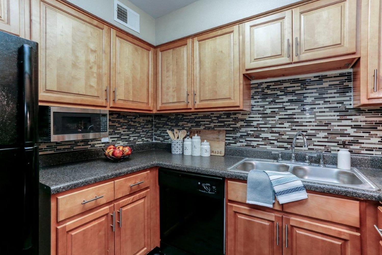 Kitchen with black appliances and tile backsplash at Mallards Landing Apartment Homes in Nashville, Tennessee