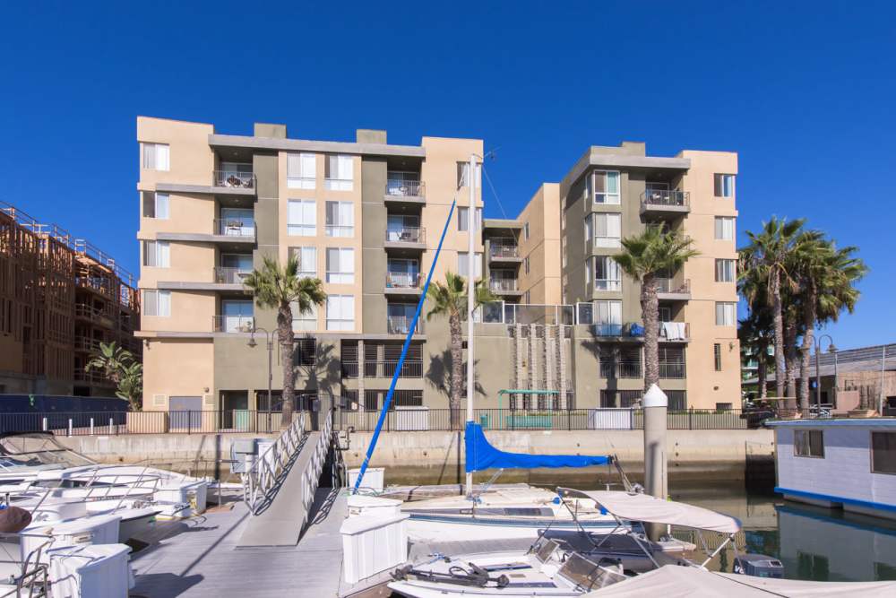 Luxury apartment building with palm trees and boats at Capri Apartments in Marina Del Rey, California
