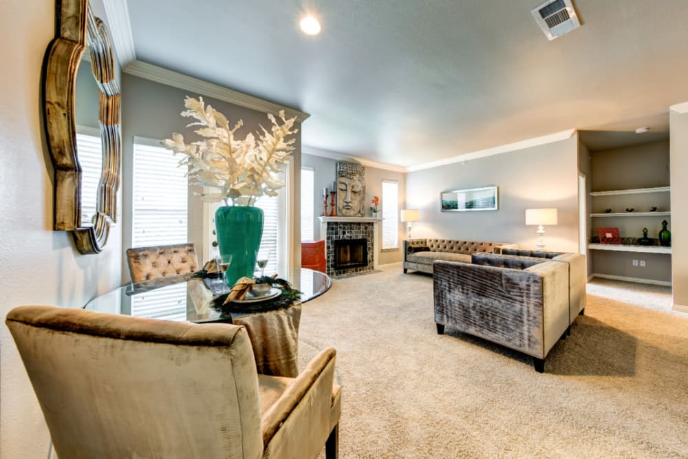 Modern style living room with sitting chairs, dining area, and built-in shelves at Marquis at Silver Oaks in Grapevine, Texas