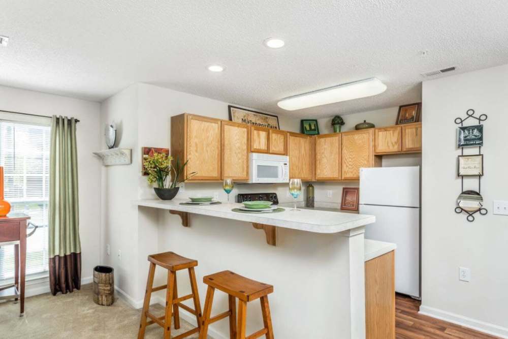 Fully equipped kitchen with appliances and connecting dining space at Lodge at Lakeshore in Greensboro, North Carolina