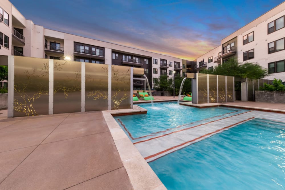 Water feature at end of pool at sunset at Marq Uptown in Austin, Texas