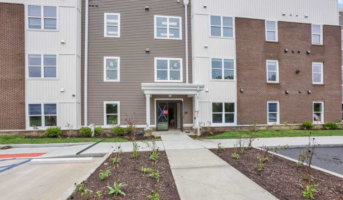 Entrance with a covered porch and landscaping at The Lofts On First in The Plains, Ohio