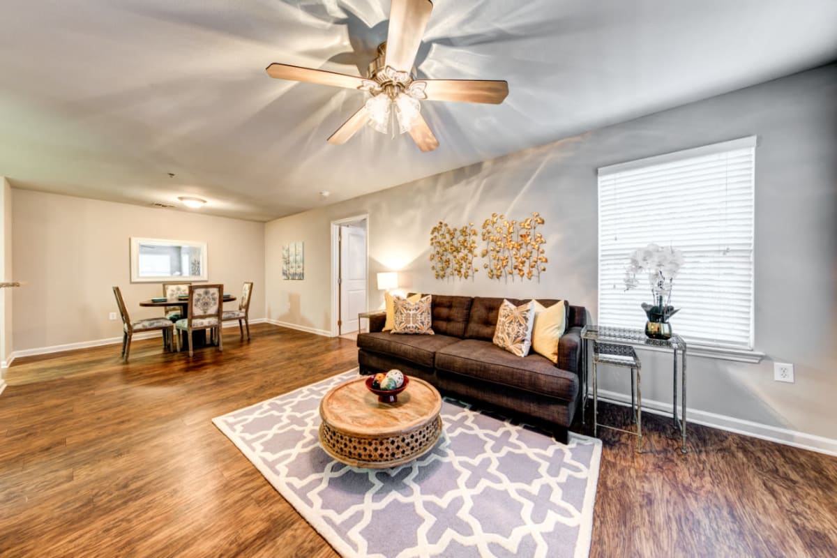 Bright and open living area with wood flooring and ceiling fan at Marquis on Cary Parkway in Morrisville, North Carolina