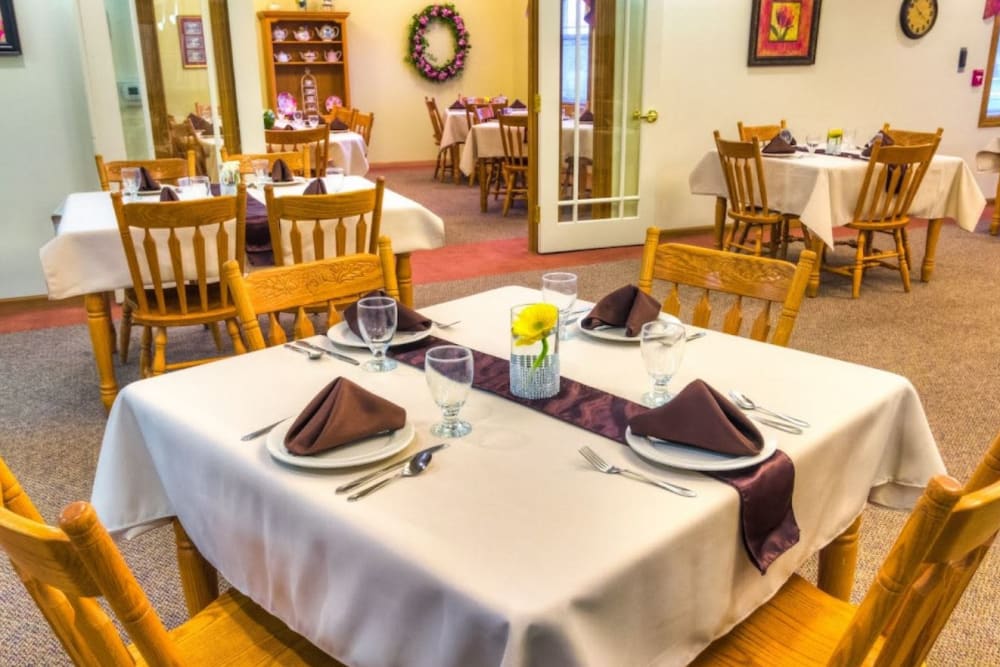 Dining room with wooden chairs and tables at Addington Place of Fairfield in Fairfield, Iowa