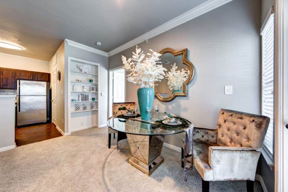 Modern style dining table and chairs next to window at Marquis at Silver Oaks in Grapevine, Texas