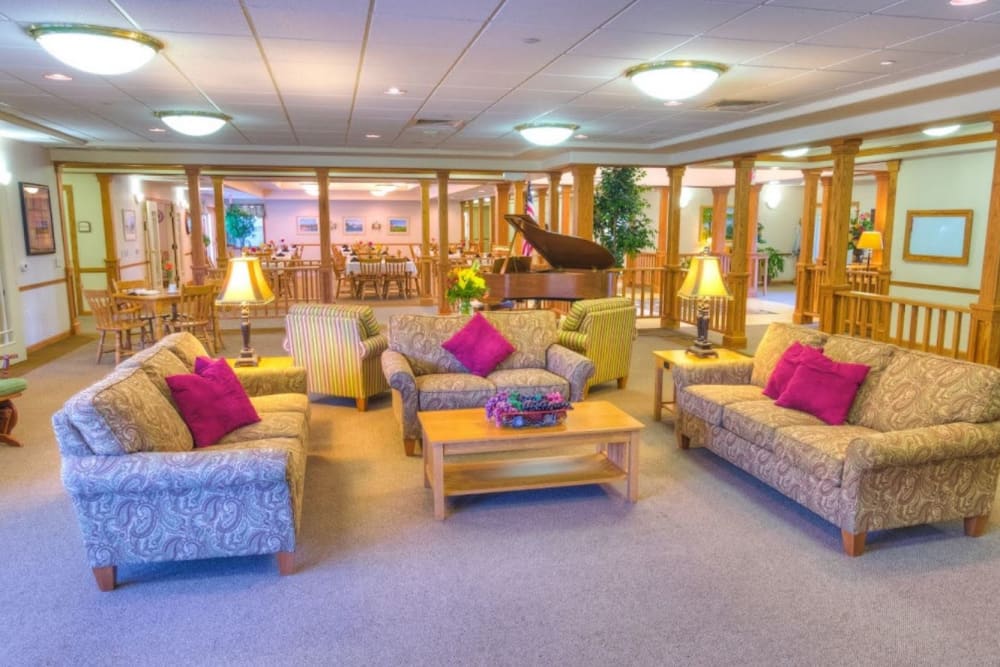 Large common area with a piano and sofa style seating at Addington Place of Fort Madison in Fort Madison, Iowa